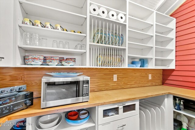 24 Sevilla St, Saint Augustine, FL 32084 - detailed view of stainless steel microwave, open shelves, and butcher block counters