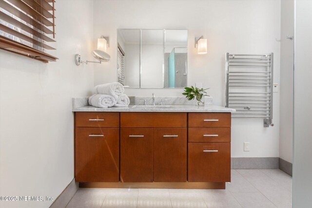 24 Sevilla St, Saint Augustine, FL 32084 - bathroom featuring radiator, vanity, baseboards, and tile patterned flooring