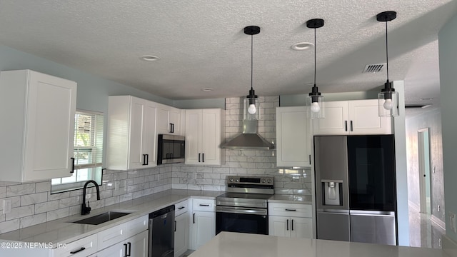 619 S 10th St, Fernandina Beach, FL 32034 - kitchen featuring stainless steel appliances, a sink, wall chimney exhaust hood, a textured ceiling, and light countertops