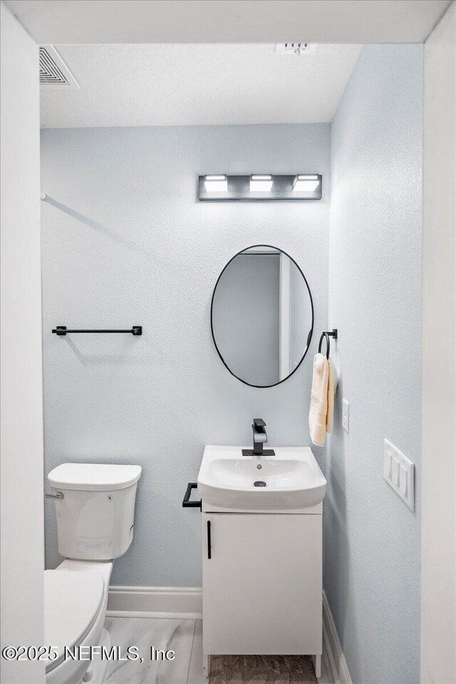 619 S 10th St, Fernandina Beach, FL 32034 - half bath featuring vanity, toilet, and baseboards