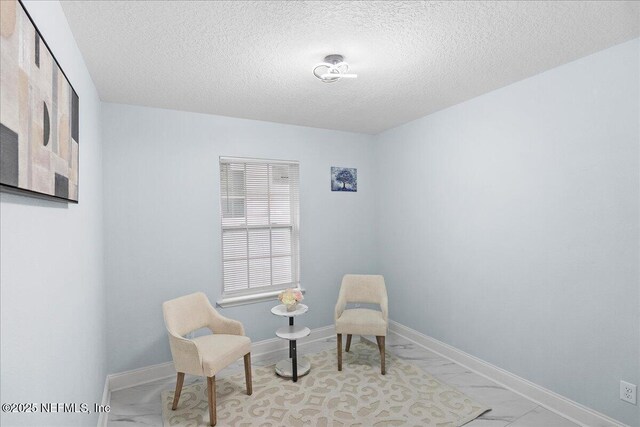 619 S 10th St, Fernandina Beach, FL 32034 - living area with light marble finish flooring, a textured ceiling, and baseboards