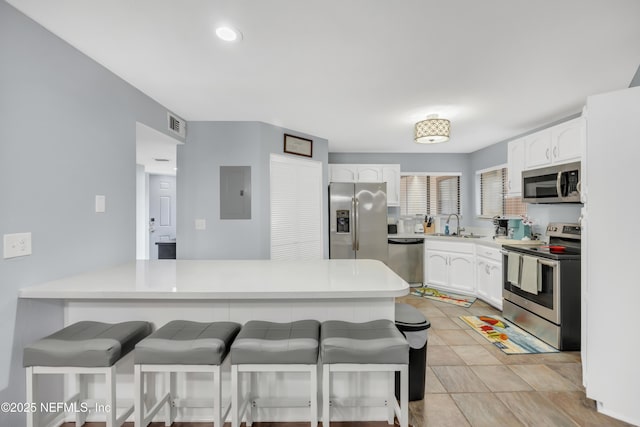 1113 Lee Rd, Jacksonville, FL 32225 - kitchen featuring stainless steel appliances, a kitchen bar, and white cabinetry