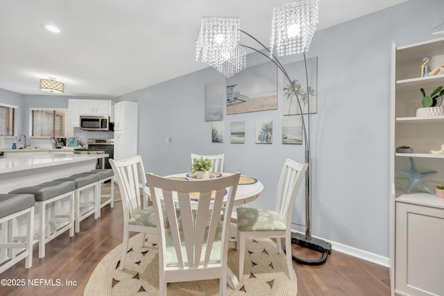 1113 Lee Rd, Jacksonville, FL 32225 - dining space featuring dark wood finished floors, a chandelier, and baseboards
