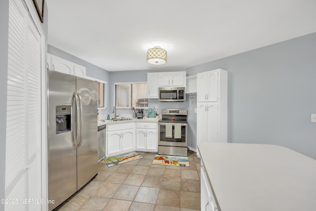 1113 Lee Rd, Jacksonville, FL 32225 - kitchen featuring appliances with stainless steel finishes, white cabinetry, a sink, and light countertops