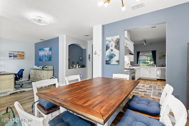 1252 Paradise Pond Rd, Saint Augustine, FL 32092 - dining room with light wood-style flooring, a textured ceiling, a desk, arched walkways, and a ceiling fan