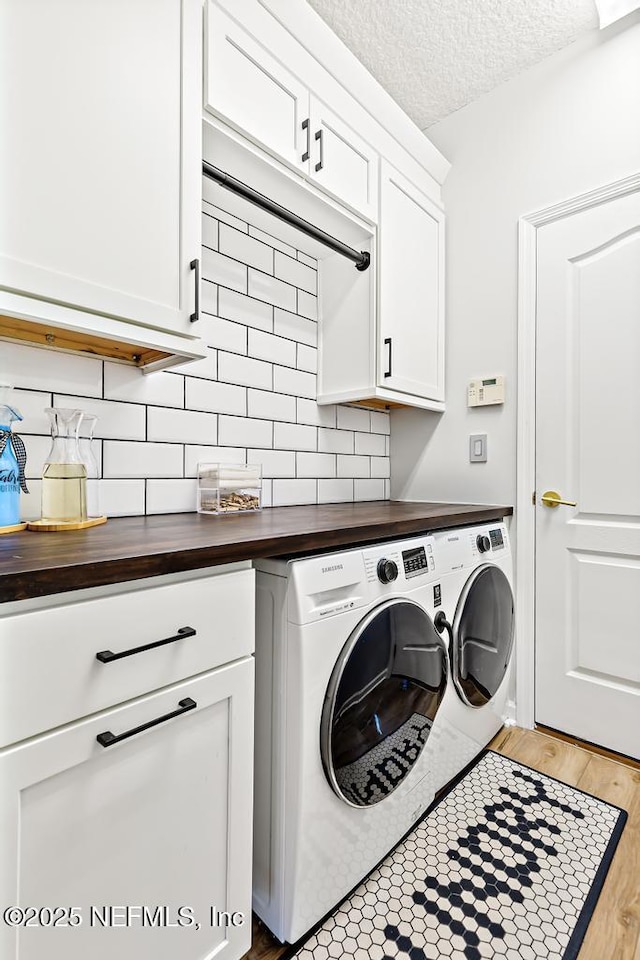 1252 Paradise Pond Rd, Saint Augustine, FL 32092 - laundry area with washing machine and dryer, cabinet space, light wood-type flooring, and a textured ceiling