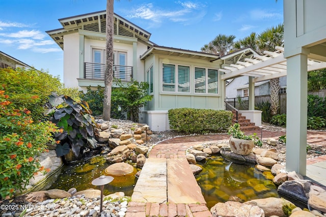 816 Ocean Front, Neptune Beach, FL 32266 - rear view of property featuring a garden pond, a balcony, a pergola, and board and batten siding