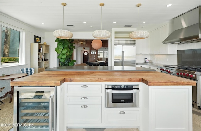 816 Ocean Front, Neptune Beach, FL 32266 - kitchen with beverage cooler, high quality appliances, wood counters, wall chimney range hood, and recessed lighting
