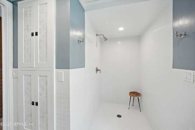 816 Ocean Front, Neptune Beach, FL 32266 - bathroom featuring tiled shower, tile walls, and a wainscoted wall