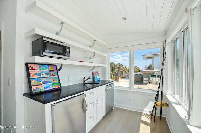 816 Ocean Front, Neptune Beach, FL 32266 - kitchen featuring stainless steel appliances, dark countertops, light wood-style flooring, a sink, and wooden ceiling