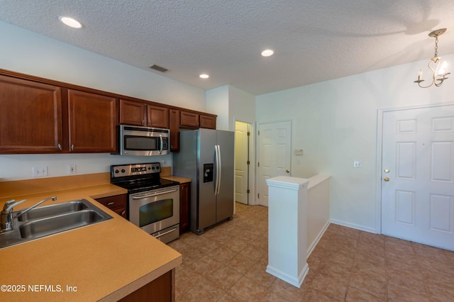 1843 Biscayne Bay Cir, Jacksonville, FL 32218 - kitchen featuring appliances with stainless steel finishes, a sink, light countertops, a textured ceiling, and a chandelier