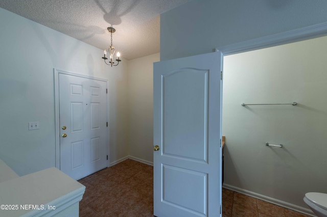 1843 Biscayne Bay Cir, Jacksonville, FL 32218 - foyer with a chandelier, a textured ceiling, baseboards, and dark tile patterned flooring