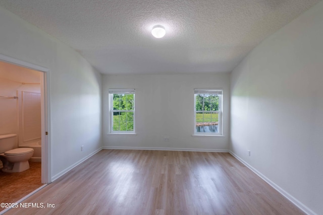 1843 Biscayne Bay Cir, Jacksonville, FL 32218 - unfurnished room featuring wood finished floors, healthy amount of natural light, a textured ceiling, and baseboards