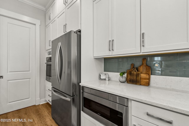 1787 Azalea St, Fernandina Beach, FL 32034 - kitchen featuring stainless steel appliances, crown molding, decorative backsplash, light stone counters, and dark wood-type flooring