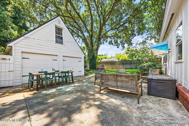 4371 Gadsden Ct, Jacksonville, FL 32207 - fenced backyard with a garage, outdoor dining space, an outdoor structure, an outdoor living space, and a patio area