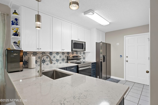 1500 Marsh Rabbit Way, Fleming Island, FL 32003 - kitchen featuring appliances with stainless steel finishes, a sink, tasteful backsplash, white cabinetry, and a textured ceiling