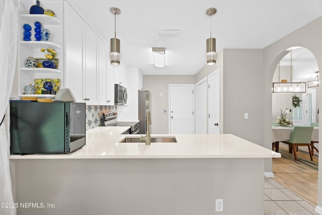 1500 Marsh Rabbit Way, Fleming Island, FL 32003 - kitchen with appliances with stainless steel finishes, a sink, open shelves, white cabinetry, and backsplash