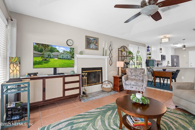 1500 Marsh Rabbit Way, Fleming Island, FL 32003 - tiled living room with ceiling fan, a sink, and a fireplace with flush hearth