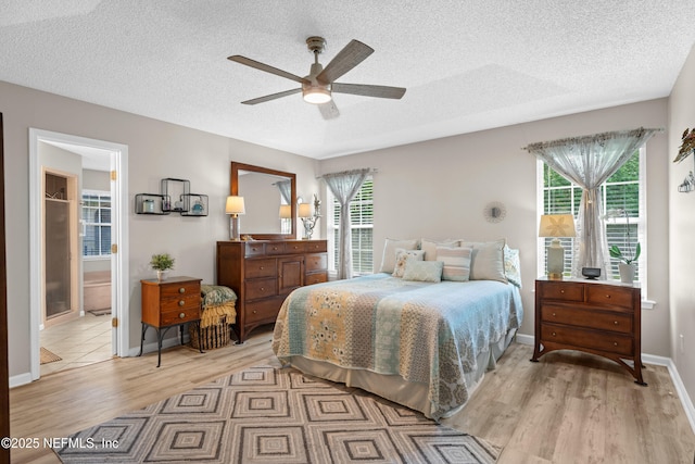 1500 Marsh Rabbit Way, Fleming Island, FL 32003 - bedroom with light wood-type flooring, a textured ceiling, baseboards, ceiling fan, and ensuite bathroom