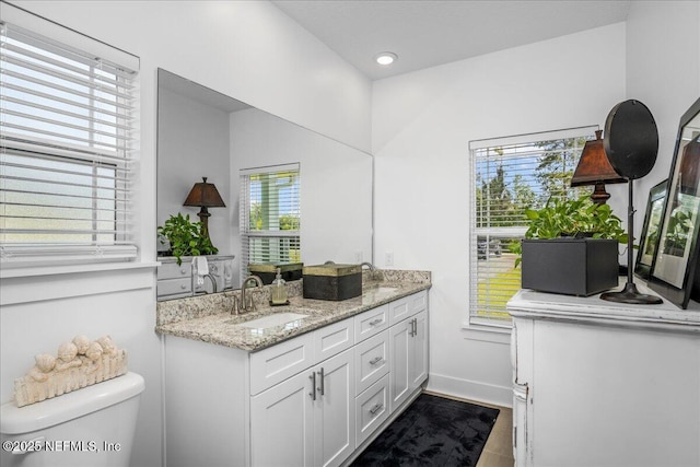 5801 SE County Road 21b, Keystone Heights, FL 32656 - bathroom with double vanity, toilet, baseboards, and recessed lighting