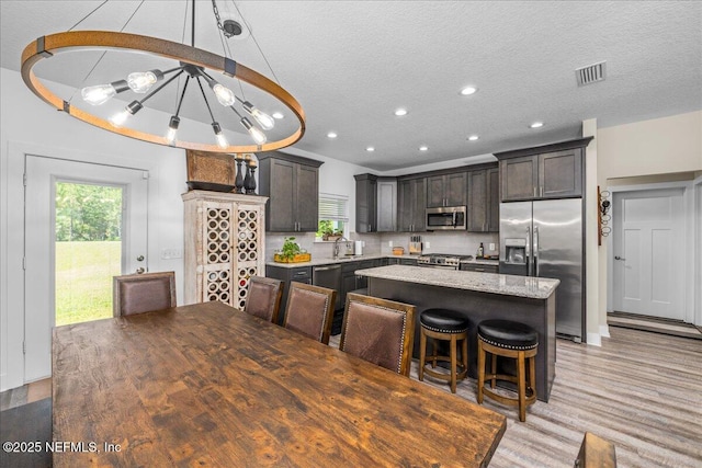 5801 SE County Road 21b, Keystone Heights, FL 32656 - kitchen with appliances with stainless steel finishes, a center island, dark brown cabinets, light wood-style floors, and recessed lighting
