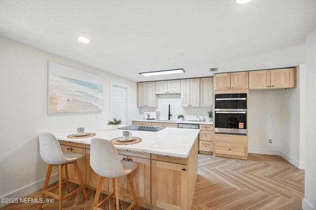 1233 Boca Grande Ave, Jacksonville, FL 32233 - kitchen with stainless steel double oven, a sink, baseboards, a breakfast bar, and light brown cabinetry