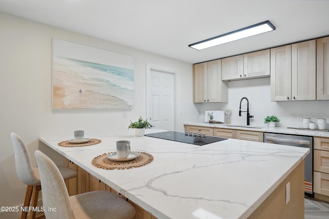 1233 Boca Grande Ave, Jacksonville, FL 32233 - kitchen with stainless steel dishwasher, a sink, black electric stovetop, a kitchen bar, and light brown cabinets