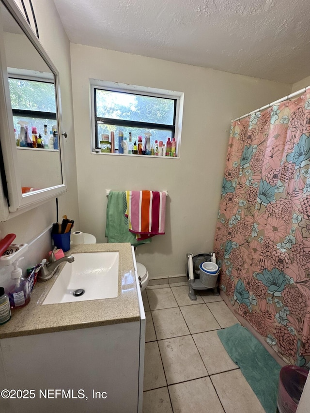6316 Pine Summit Dr, Jacksonville, FL 32211 - full bathroom featuring toilet, plenty of natural light, vanity, tile patterned floors, and a textured ceiling