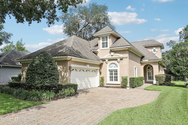 4640 Tuscan Wood Ct, Saint Augustine, FL 32092 - view of front of home with stucco siding, a garage, a shingled roof, driveway, and a front yard