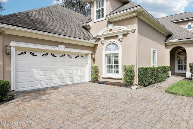 4640 Tuscan Wood Ct, Saint Augustine, FL 32092 - view of front of house featuring roof with shingles, decorative driveway, stucco siding, and an attached garage