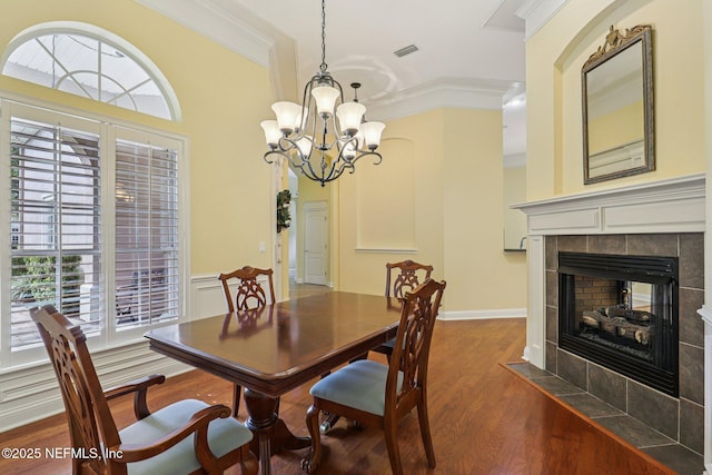 4640 Tuscan Wood Ct, Saint Augustine, FL 32092 - dining space featuring dark wood-style flooring, ornamental molding, a chandelier, plenty of natural light, and a tiled fireplace