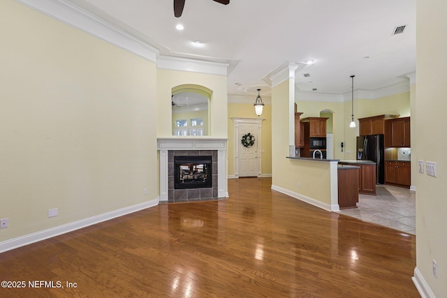 4640 Tuscan Wood Ct, Saint Augustine, FL 32092 - unfurnished living room featuring ceiling fan, ornamental molding, wood finished floors, and a tiled fireplace