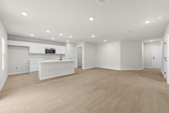 5969 Flicker Ave, Jacksonville, FL 32219 - unfurnished living room featuring recessed lighting, baseboards, a sink, and light wood-type flooring