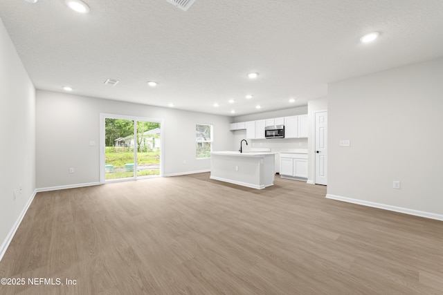 5969 Flicker Ave, Jacksonville, FL 32219 - unfurnished living room featuring light wood-style flooring, recessed lighting, and baseboards
