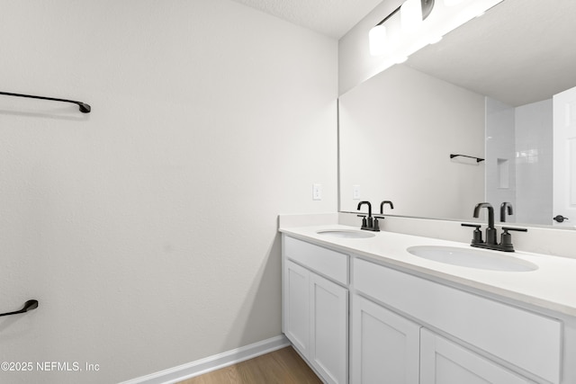 5969 Flicker Ave, Jacksonville, FL 32219 - bathroom featuring wood finished floors, double vanity, and baseboards