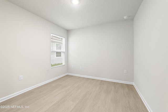 5969 Flicker Ave, Jacksonville, FL 32219 - unfurnished room featuring light wood-style flooring, baseboards, a smoke detector, and a textured ceiling
