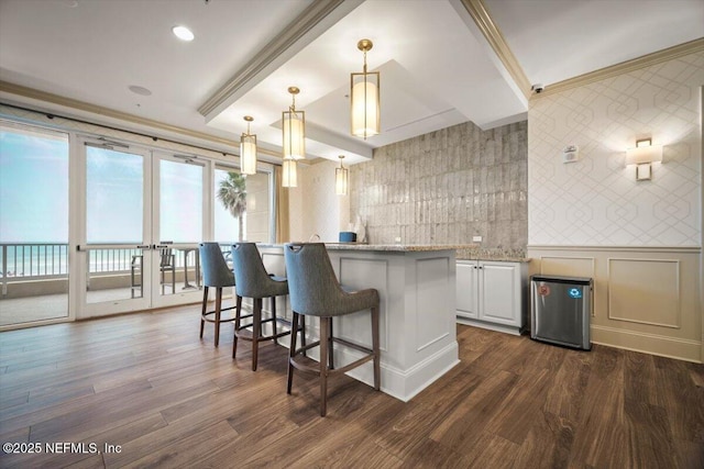 1031 1st St S Unit 1202, Jacksonville Beach, FL 32250 - kitchen featuring a breakfast bar area, dark wood finished floors, ornamental molding, decorative light fixtures, and a center island