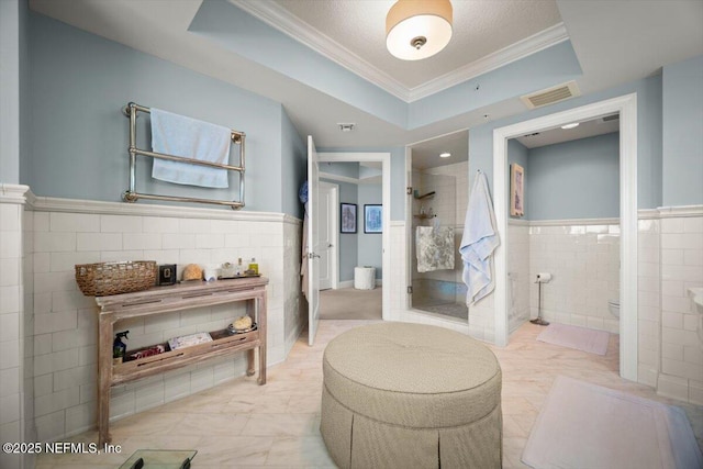 1031 1st St S Unit 1202, Jacksonville Beach, FL 32250 - bathroom featuring toilet, a shower stall, tile walls, ornamental molding, and a wainscoted wall