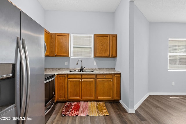 209 E 17th St, Jacksonville, FL 32206 - kitchen with appliances with stainless steel finishes, a sink, dark wood finished floors, and brown cabinetry