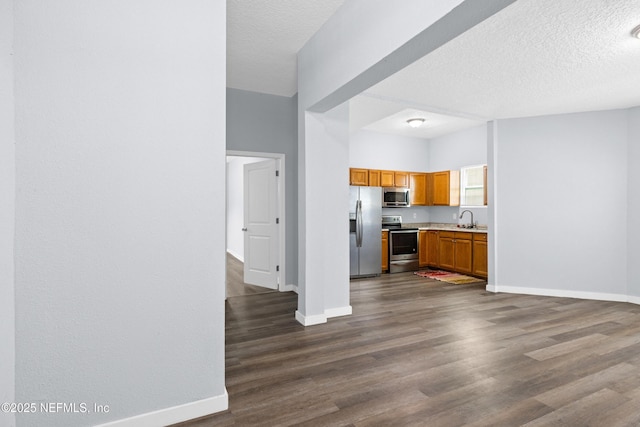 209 E 17th St, Jacksonville, FL 32206 - kitchen with appliances with stainless steel finishes, a sink, baseboards, light countertops, and a textured ceiling