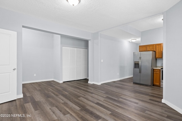 209 E 17th St, Jacksonville, FL 32206 - kitchen featuring appliances with stainless steel finishes, brown cabinets, dark wood finished floors, baseboards, and a textured ceiling
