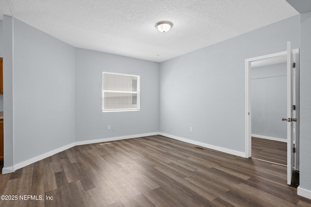 209 E 17th St, Jacksonville, FL 32206 - spare room featuring dark wood-type flooring, a textured ceiling, and baseboards