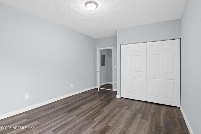 209 E 17th St, Jacksonville, FL 32206 - unfurnished bedroom with dark wood finished floors, baseboards, a textured ceiling, and a closet