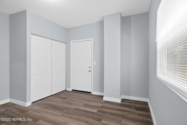 209 E 17th St, Jacksonville, FL 32206 - foyer featuring dark wood-type flooring, baseboards, and a textured ceiling