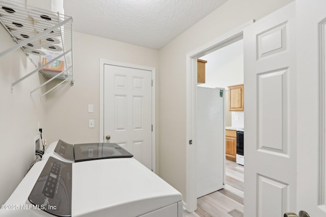 1260 Winding Brook Ct, Middleburg, FL 32068 - laundry area with washing machine and clothes dryer, light wood-type flooring, and a textured ceiling