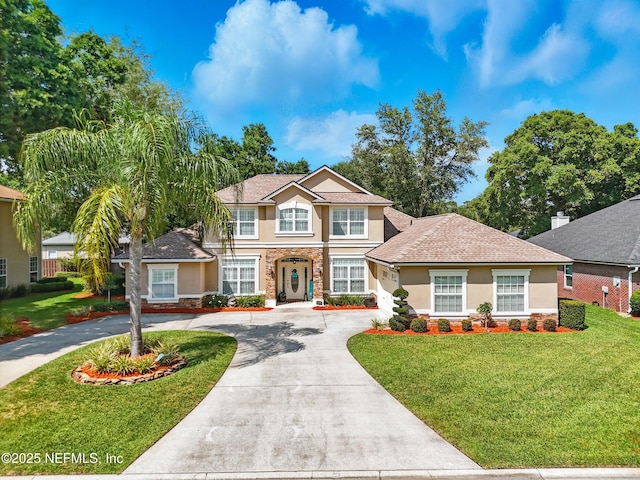 1077 Waterfall Dr, Jacksonville, FL 32225 - traditional home featuring stucco siding, stone siding, curved driveway, and a front lawn