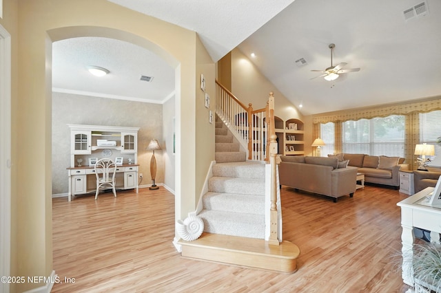 1077 Waterfall Dr, Jacksonville, FL 32225 - staircase featuring ceiling fan, wood finished floors, arched walkways, vaulted ceiling, and baseboards