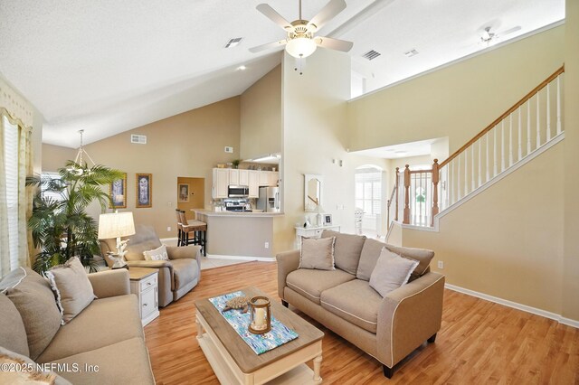1077 Waterfall Dr, Jacksonville, FL 32225 - living room featuring light wood-type flooring, ceiling fan, high vaulted ceiling, stairs, and baseboards