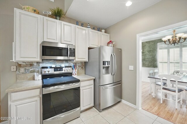 1077 Waterfall Dr, Jacksonville, FL 32225 - kitchen with appliances with stainless steel finishes, a chandelier, light countertops, and light tile patterned flooring