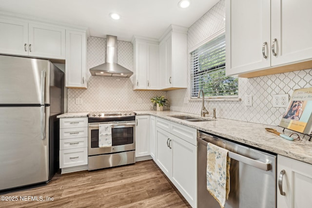 4580 Carolyn Cove Ln N, Jacksonville, FL 32258 - kitchen featuring stainless steel appliances, wall chimney range hood, a sink, white cabinetry, and recessed lighting
